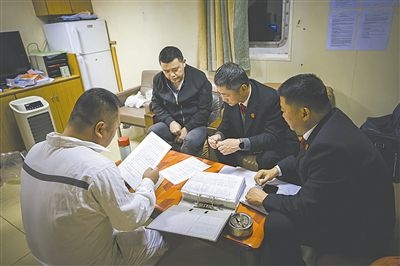 圖②：法官向船長(zhǎng)講解相關(guān)法律規(guī)定，查看船舶資料，并與船方辦理扣押船舶的手續(xù)。