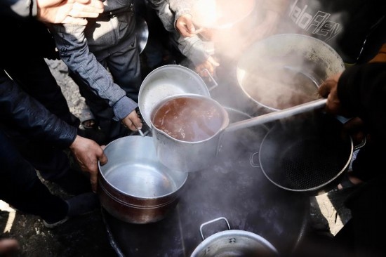  2月27日，在加沙地帶北部的杰巴利耶難民營，人們領取食物。新華社發(fā)（穆罕默德·阿里攝）