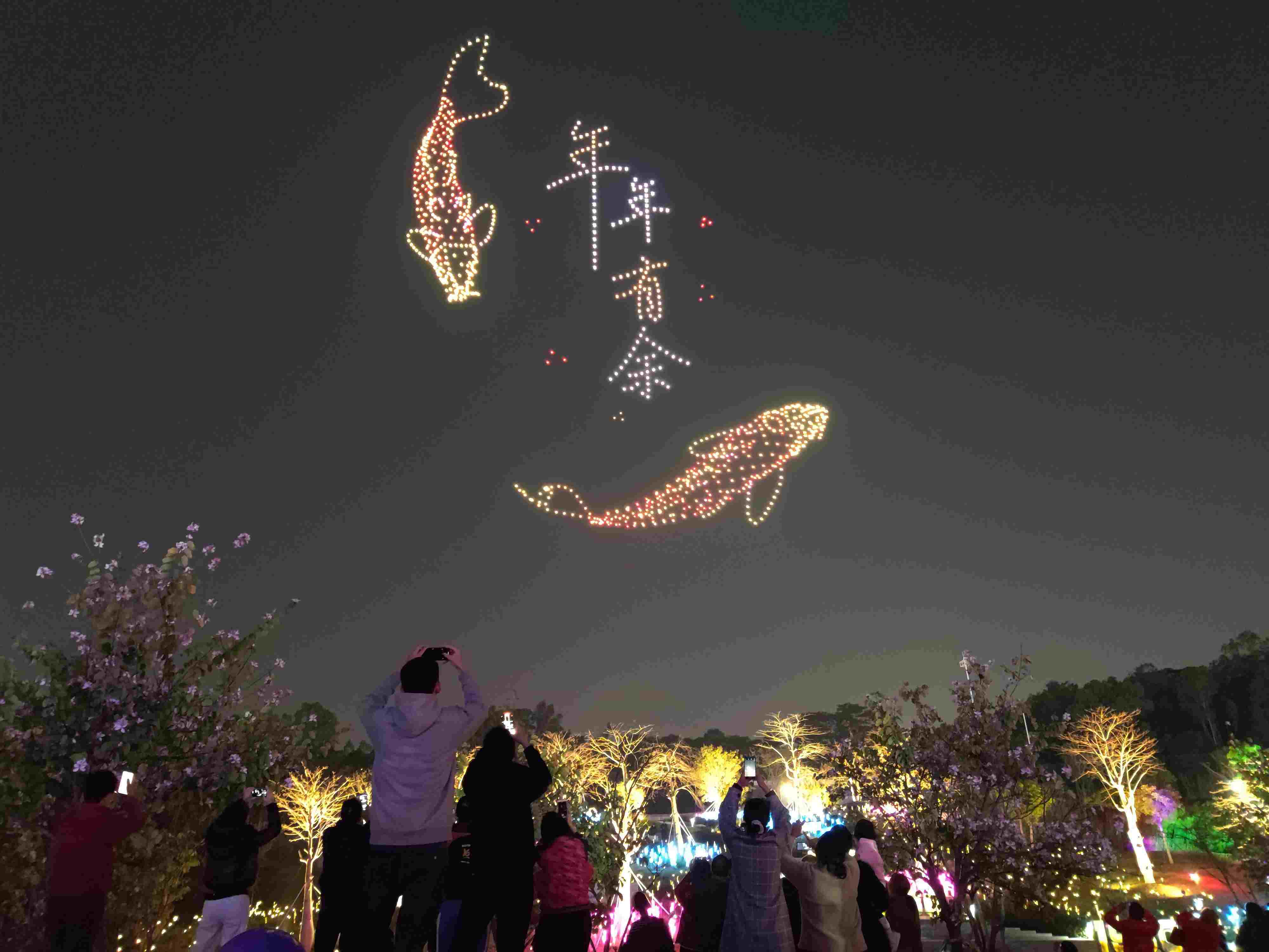 △ 2024年2月10日，深圳北站中心公園，春節(jié)主題無人機(jī)燈光秀引來眾多游客駐足觀看。