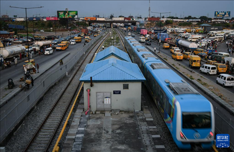 3月4日，在尼日利亞拉各斯，一列輕軌藍(lán)線列車行駛至公路交通擁堵路段附近。新華社記者 韓旭 攝