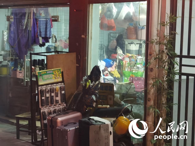 南寧“城中村”一裁縫鋪老板將電線從店內(nèi)拉出為電動(dòng)自行車充電。人民網(wǎng) 覃心攝