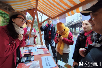 1月6日，“2024成都蒲江柑甜采摘節(jié)”上，記者見到了小萌（左一）和許多年輕人忙著做訪客接待、現(xiàn)場布置、票務核對、采摘服務等工作。人民網(wǎng)記者朱虹攝