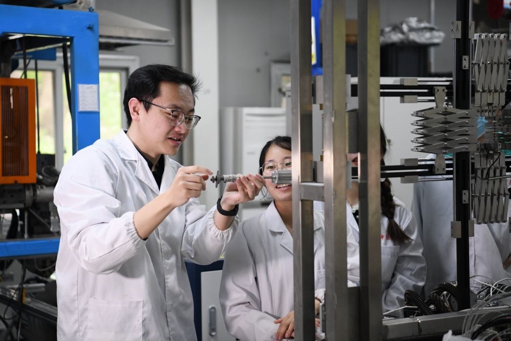 2024年4月6日，在位于安徽合肥的中國科學(xué)技術(shù)大學(xué)，安徽省先進(jìn)功能高分子薄膜工程實驗室團(tuán)隊成員朱健和（左）在和同事討論實驗設(shè)備的設(shè)計方案。