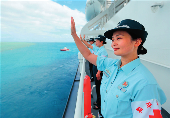中國(guó)海軍“和平方舟”號(hào)醫(yī)院船結(jié)束訪問(wèn)湯加時(shí)，任務(wù)官兵中的文職人員向歡送人群揮手告別（2023年8月4日攝）。徐巍攝/本刊