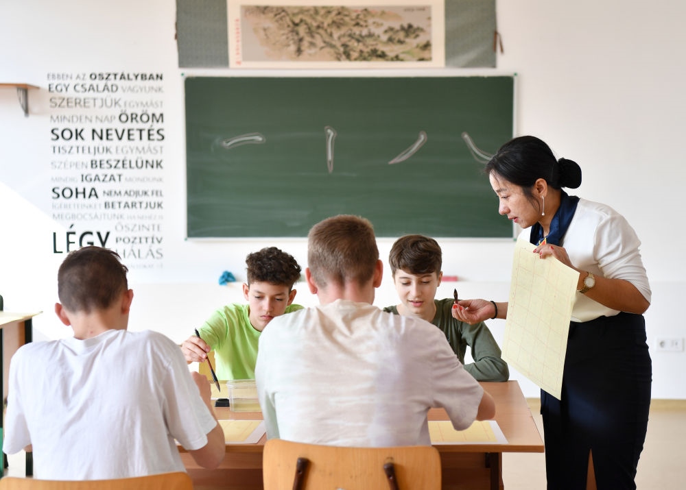 2023年2月24日，在匈牙利首都布達佩斯的匈中雙語學校，中國教師指導學生們學習書法。新華社記者 連漪 攝
