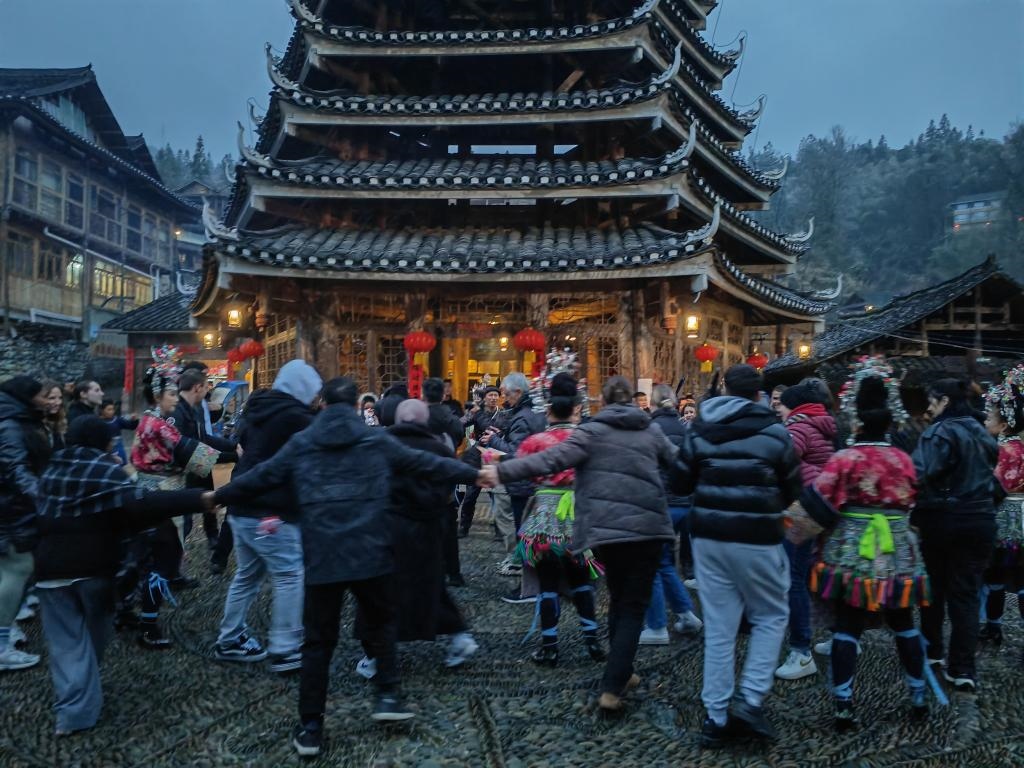 法國(guó)青年與當(dāng)?shù)卮迕駹渴痔?。新華社記者 羅羽 攝