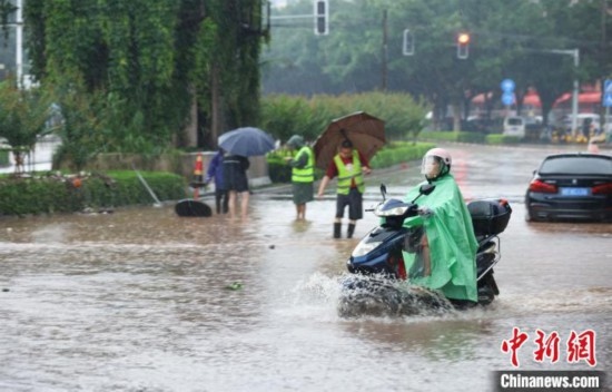 5月10日，廣西沿海遭遇強降雨。圖為欽州市民眾在積澇中出行。陸敏 攝