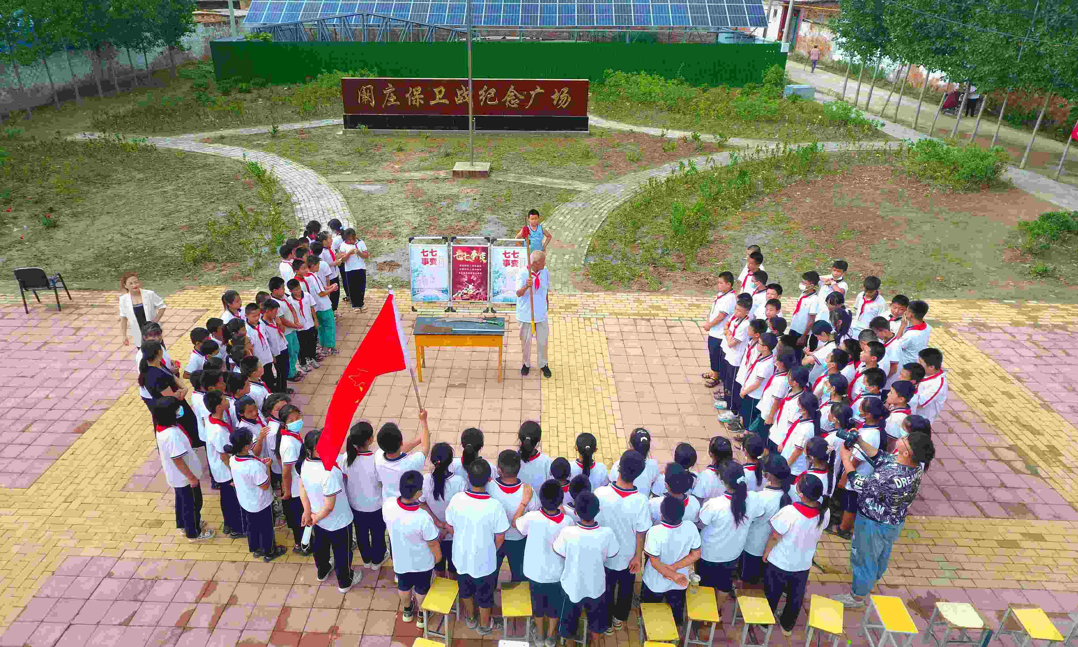 2022年7月6日，山東省聊城市，在茌平區(qū)菜屯鎮(zhèn)闞莊村的闞莊保衛(wèi)戰(zhàn)紀(jì)念廣場，闞莊保衛(wèi)戰(zhàn)親歷者王光木老人為小學(xué)生們講述抗戰(zhàn)故事，展示大刀、長矛。