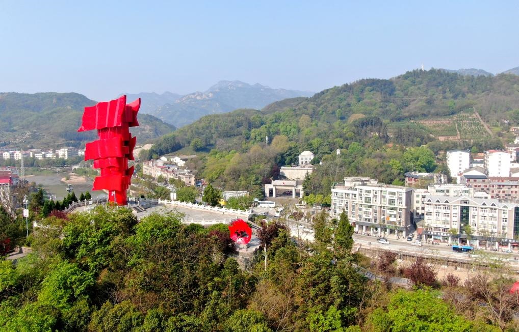 這是2021年4月9日拍攝的鄂豫皖蘇區(qū)首府革命博物館附近的英雄山上的“紅旗飄飄”主題雕塑（無人機(jī)照片）。新華社發(fā)