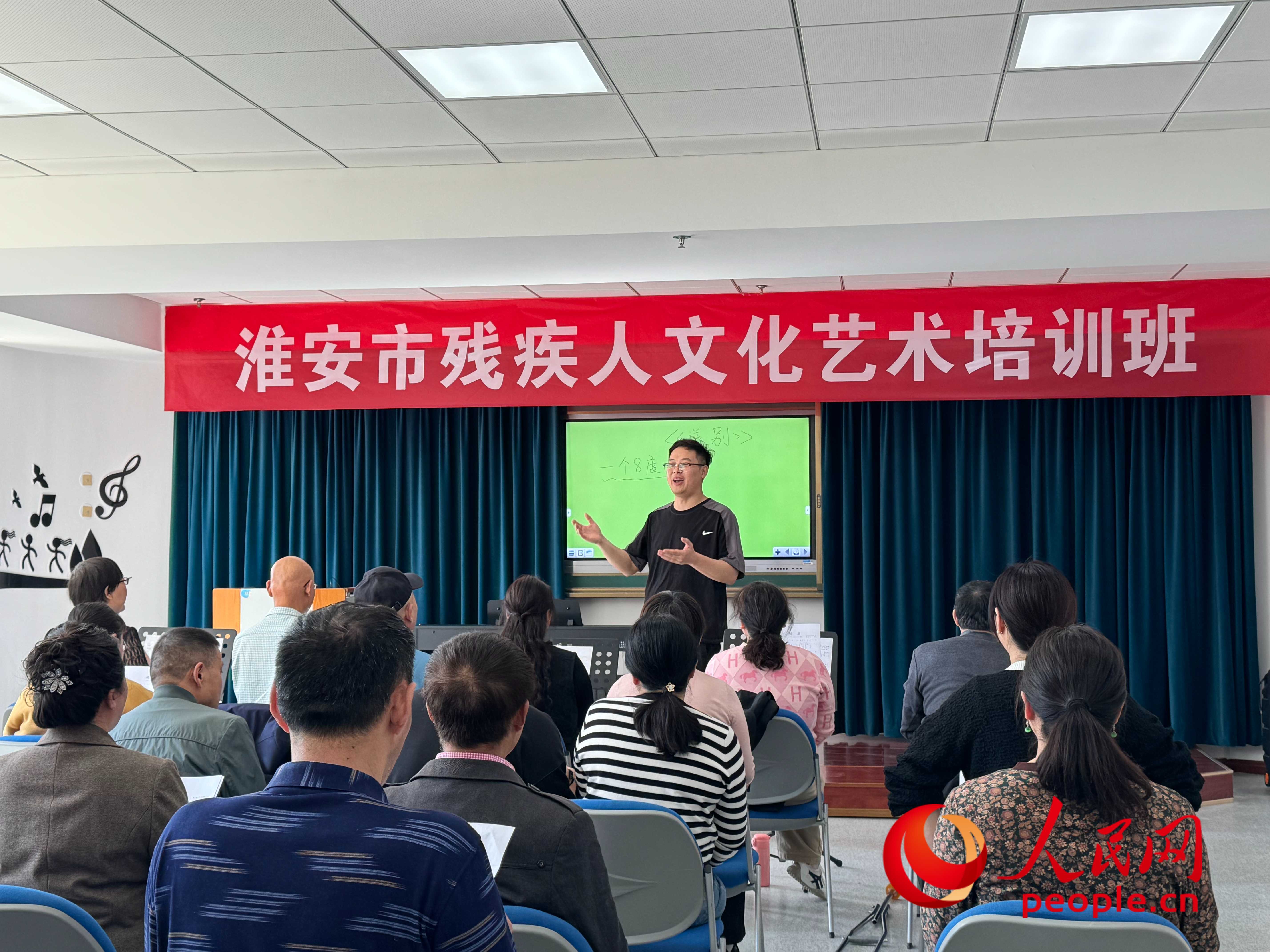 在淮安市殘疾人文化藝術(shù)培訓(xùn)班上，聲樂老師在教殘疾人唱《送別》這首歌曲。人民網(wǎng) 周靜圓攝