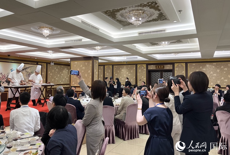 國家級非物質文化遺產(chǎn)、全聚德片鴨工藝吸引代表團成員拍照留念。
