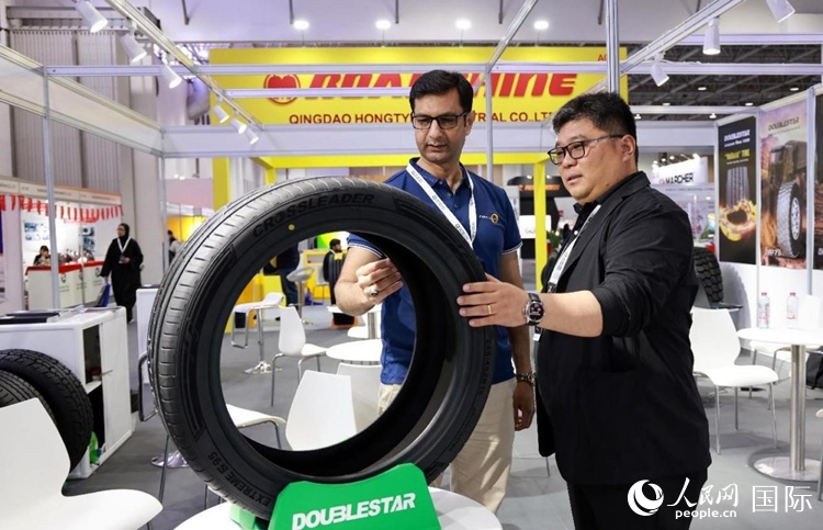 工作人員向客戶展示雙星電動汽車輪胎。和傳統(tǒng)汽車輪胎相比，電動汽車輪胎具有更高承載能力、更加靜音舒適、更好極速抓地、更低滾動阻力等特點。人民網(wǎng)記者 管克江攝