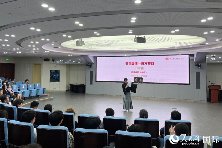 日本大學(xué)生介紹能樂知識(shí)。人民網(wǎng)記者 陳思攝