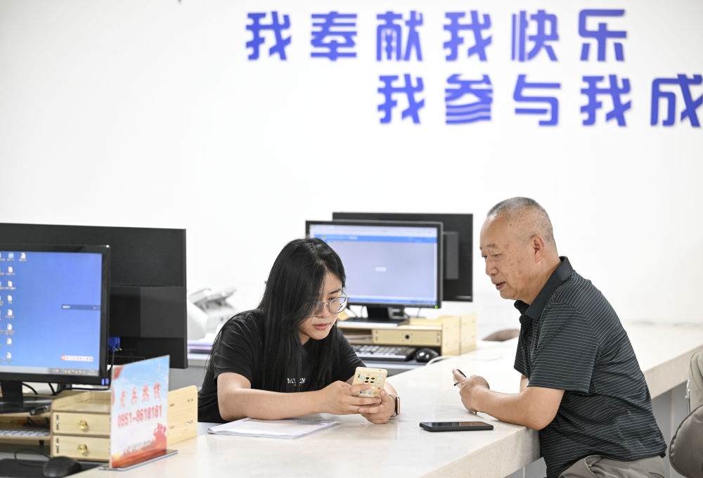 6月20日，在長城花園社區(qū)黨群服務中心，工作人員幫助居民辦理業(yè)務。