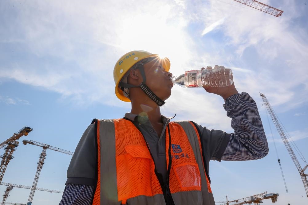 6月18日，在江蘇省無錫市奧體三期項目施工現(xiàn)場，中建二局工人在喝水解暑。新華社發(fā)（朱吉鵬 攝）