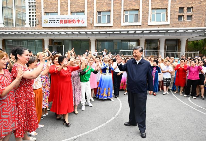 2022年7月13日，習(xí)近平總書記在新疆烏魯木齊市天山區(qū)固原巷社區(qū)考察時，向各族群眾揮手致意。