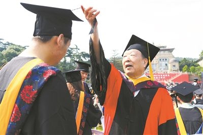 2017年6月22日，李德仁（右一）參加武漢大學(xué)畢業(yè)典禮并為畢業(yè)生撥穗。