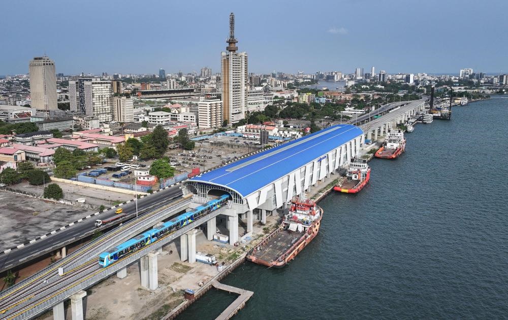 2024年3月2日，在尼日利亞拉各斯，一列輕軌藍線列車駛?cè)氪a頭站（無人機照片）。拉各斯輕軌藍線是西非地區(qū)首條由中國企業(yè)自主設(shè)計、建造、施工、運營的電氣化城市軌道交通項目。新華社記者 韓旭 攝