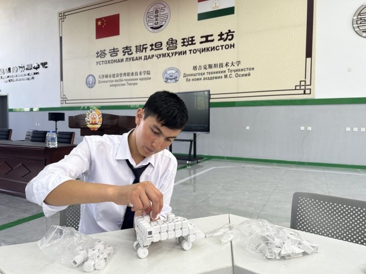 在塔吉克斯坦魯班工坊內(nèi)，學員正在操作能力源創(chuàng)新套件。本報記者 屈佩 攝