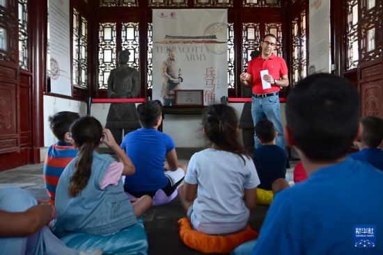 7月4日，在馬耳他桑塔露琪亞市的中國古典園林“靜園”，人們聆聽關(guān)于兵馬俑的講解。新華社發(fā)（喬納森·博格 攝）