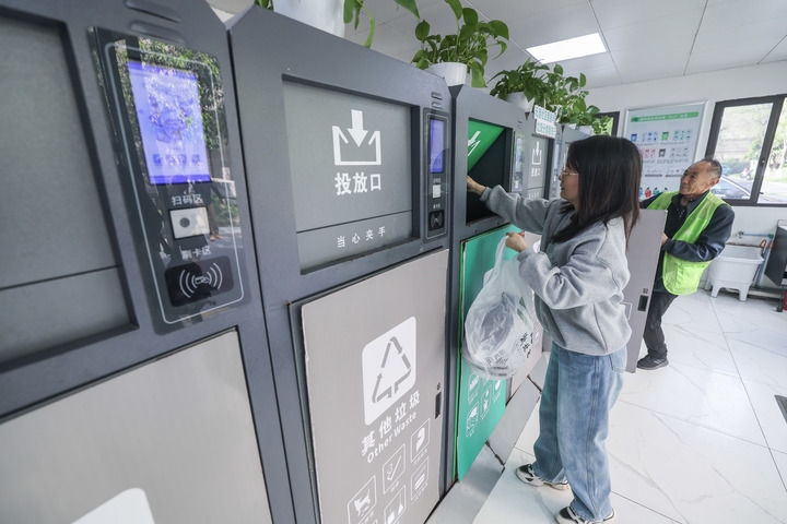 2024年4月10日，在浙江省湖州市吳興區(qū)飛英街道新華府小區(qū)內(nèi)，居民在垃圾分類智能系統(tǒng)的指導(dǎo)下進行垃圾分類投放，居民的投放情況將實時匯總到智慧服務(wù)平臺，會有相應(yīng)的積分獎勵。新華社記者 徐昱 攝