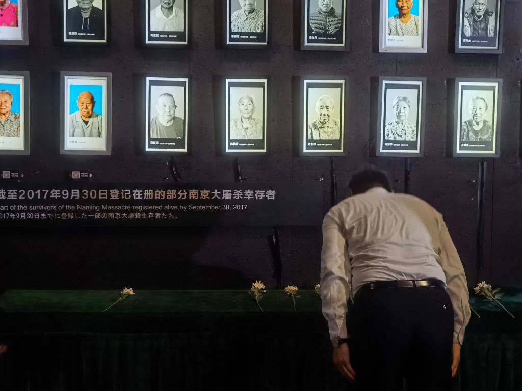 7月18日，人們向離世的南京大屠殺幸存者獻花、鞠躬。新華社記者邱冰清 攝