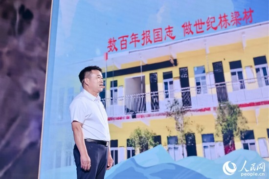 張玉滾分享用一根扁擔(dān)送孩子們走出大山的故事。人民網(wǎng)攝