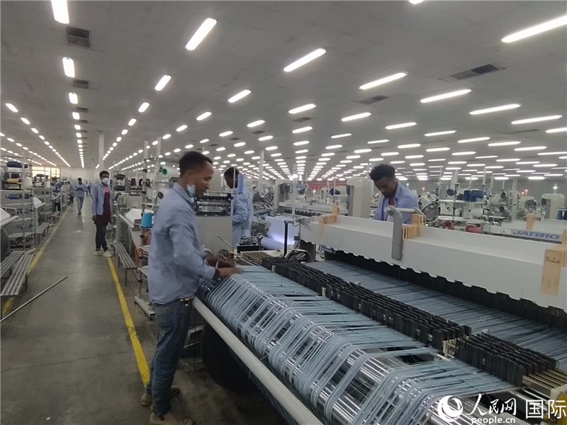 無錫金茂埃塞面料廠車間內(nèi)，當?shù)毓と苏谝唤z不茍地作業(yè)。人民網(wǎng)記者 黃培昭攝