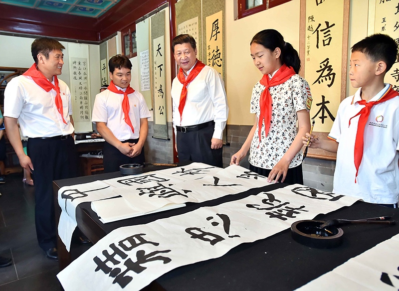 2014年5月30日，習(xí)近平總書記來到北京市海淀區(qū)民族小學(xué)，參加慶?！傲弧眹H兒童節(jié)活動。這是總書記觀看學(xué)生書寫的毛筆字。