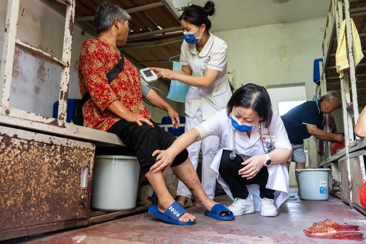 2024年7月30日，在湖南省湘潭縣河口中學安置點，醫(yī)務人員為受洪水影響而轉移安置的群眾檢查身體。 新華社記者 陳思汗 攝