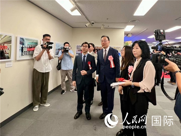 中國(guó)國(guó)際航空日韓地區(qū)支社支社長(zhǎng)馮力為中國(guó)駐日本大使館臨時(shí)代辦施泳等嘉賓介紹展出圖片。人民網(wǎng) 許可攝