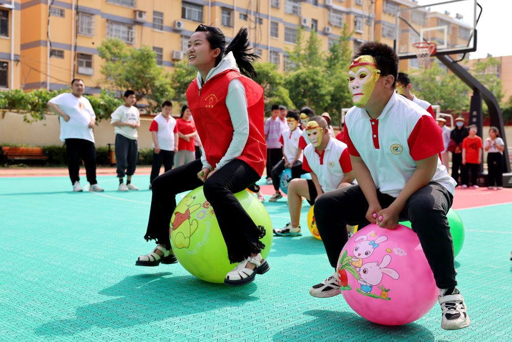 2024年5月17日，在山東省棗莊市市中區(qū)特殊教育中心，青年志愿者與智力障礙學(xué)生一起做游戲。新華社發(fā)（孫中喆攝）