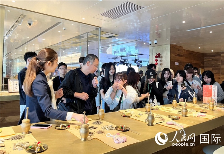 1. 日中友好協(xié)會青年代表團(tuán)一行學(xué)習(xí)中醫(yī)香囊制作工序。（人民網(wǎng)記者陳思 攝）