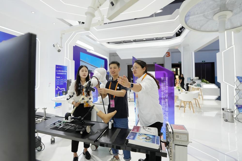 9月11日，一位媒體記者（中）在2024年服貿(mào)會(huì)國家會(huì)議中心會(huì)場體驗(yàn)北京納通科技集團(tuán)有限公司的膝關(guān)節(jié)置換手術(shù)機(jī)器人。新華社記者鞠煥宗 攝
