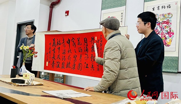 旅秘書(shū)法家向現(xiàn)場(chǎng)觀眾展示書(shū)法作品。人民網(wǎng)記者 宋亦然攝