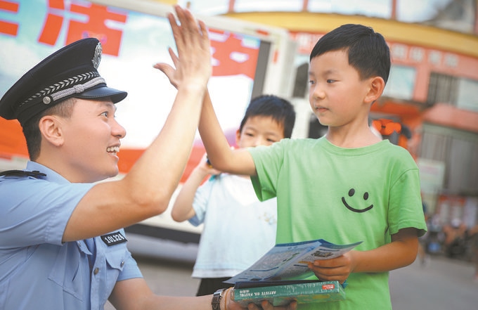 ▲7月10日，江西省吉安市公安局吉州分局組織民警深入轄區(qū)開展安全宣傳，民警向小朋友講解防溺水知識(shí)。朱文杰攝