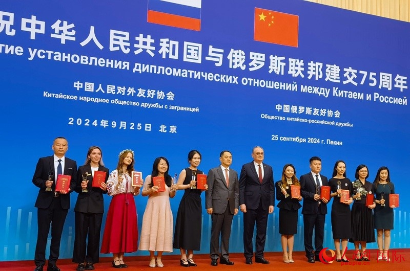 楊萬(wàn)明會(huì)長(zhǎng)和莫爾古洛夫大使為10位中俄青年友好微視頻創(chuàng)意大賽獲獎(jiǎng)代表頒獎(jiǎng)。人民網(wǎng)記者 李明琪攝