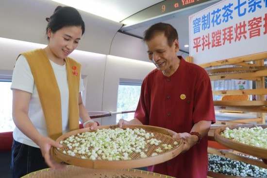 10月1日，福州市茉莉花茶窨制工藝代表性傳承人張子建與旅客在G1634次列車上制作茉莉花茶。新華社記者周義 攝
