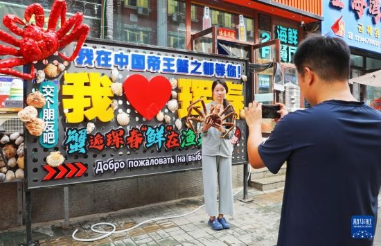 9月21日，游客在吉林省琿春市一處帝王蟹元素主題裝飾前拍照留念。新華社發(fā)