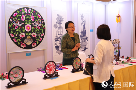 青海非遺文化傳承人向嘉賓介紹展品。人民網(wǎng)實(shí)習(xí)生姚欣可攝