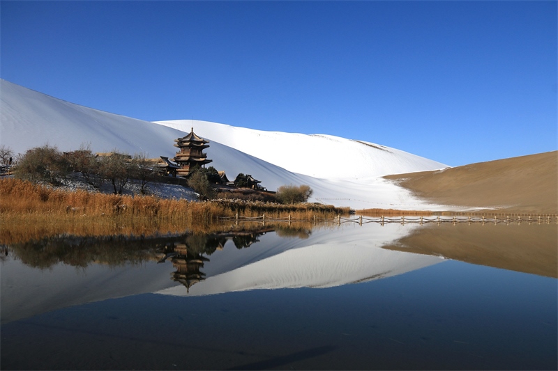 鳴沙山月牙泉景區(qū)雪景。敦煌市委宣傳部供圖，張曉亮攝