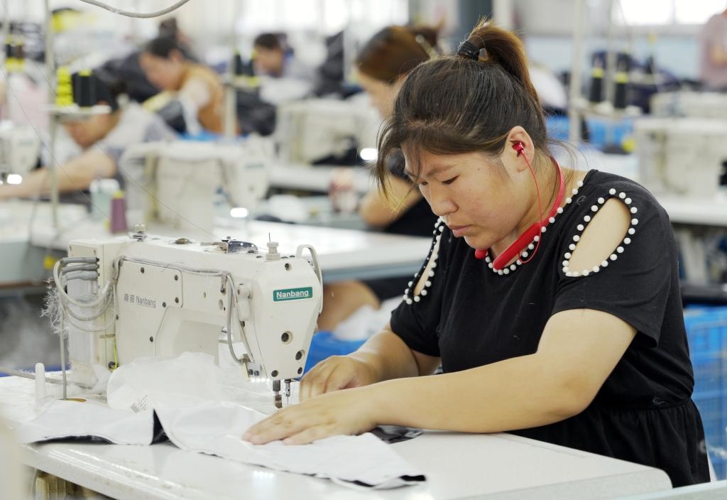 5月20日，村民在李寨村服裝加工廠內(nèi)忙碌。河南省周口市沈丘縣馮營鎮(zhèn)李寨村地處豫東平原。近年來，乘著脫貧攻堅與鄉(xiāng)村振興政策的東風(fēng)，李寨村積極探索產(chǎn)業(yè)發(fā)展模式，通過“龍頭企業(yè)+村集體經(jīng)濟(jì)+農(nóng)戶”的方式，逐漸發(fā)展形成肉牛養(yǎng)殖、設(shè)施農(nóng)業(yè)、服裝加工、康養(yǎng)民宿等產(chǎn)業(yè)，以產(chǎn)業(yè)振興助力鄉(xiāng)村振興。新華社記者 李嘉南 攝