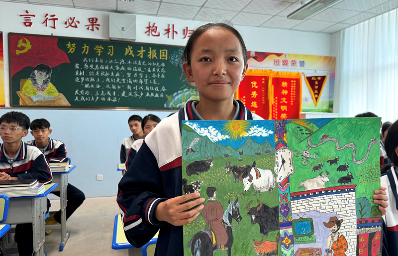 果洛西寧民族中學(xué)學(xué)生尼東拉毛在主題思政課上展示表現(xiàn)現(xiàn)代化家鄉(xiāng)的作品。