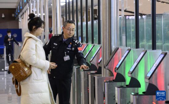 1月2日，大興機(jī)場邊檢站警察指導(dǎo)旅客使用自助出境設(shè)備。新華社記者 李欣 攝