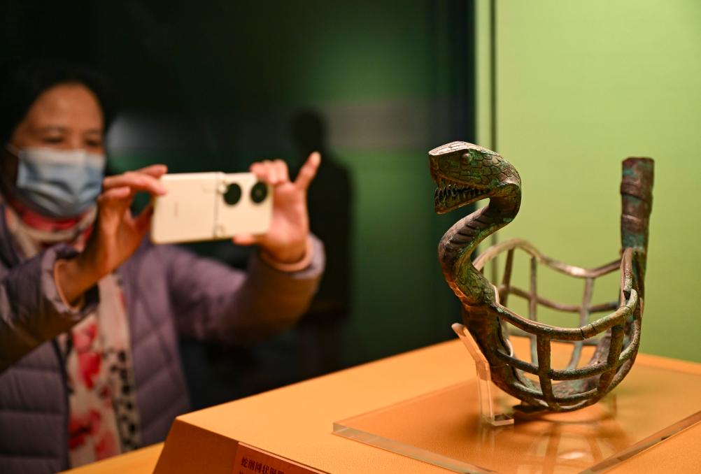 1月14日，觀眾在上海博物館蛇年迎春展拍攝展品蛇綱網(wǎng)狀銅器。新華社發(fā)（陳浩明攝）