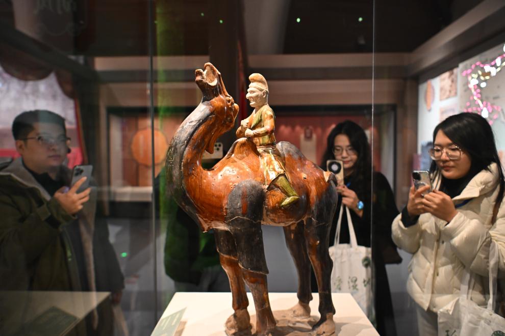 1月15日，觀眾在拍攝“長(zhǎng)安三萬(wàn)里——陜西唐代文物精華展”展出的三彩胡人騎駝俑。（新華社記者 孫凡越 攝）