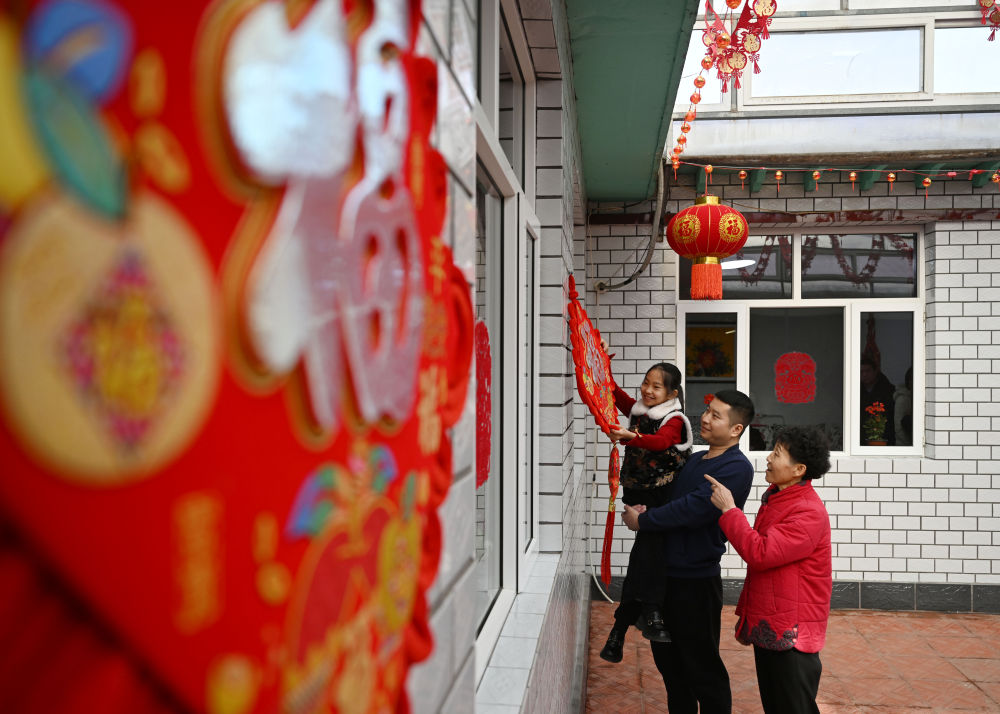 天津市西青區(qū)辛口鎮(zhèn)第六埠村村民在院子里掛“福”字（2024年2月1日攝）。新華社記者 趙子碩 攝