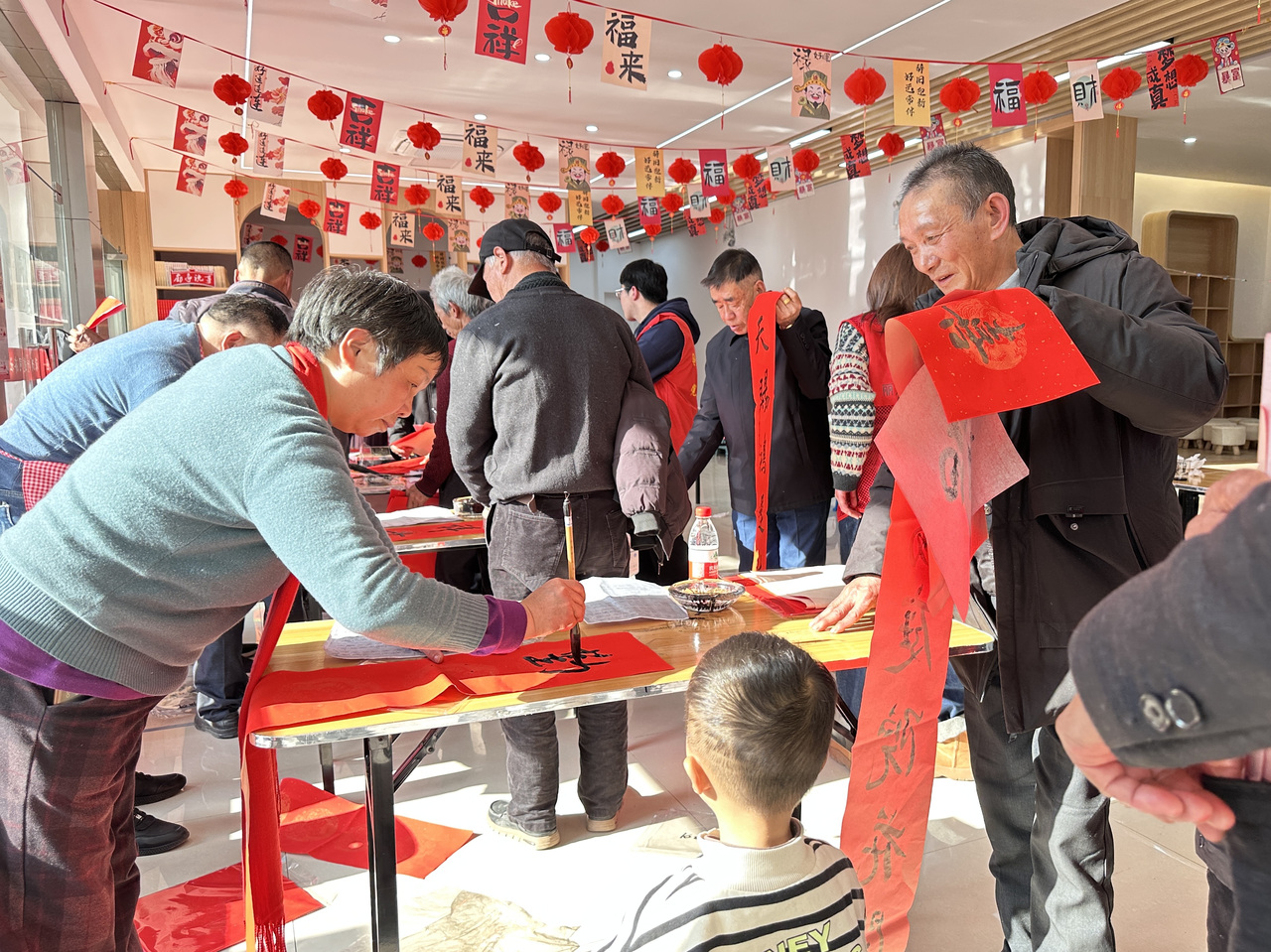 今年春節(jié)前夕，慶元縣濛洲街道同濟新村，一場送春聯(lián)活動熱鬧舉行。慶元縣融媒體中心 供圖