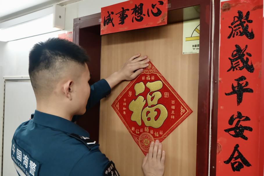 1月27日，在中國(guó)海警海鷗艦上，執(zhí)法員貼春聯(lián)福字慶祝農(nóng)歷春節(jié)。
