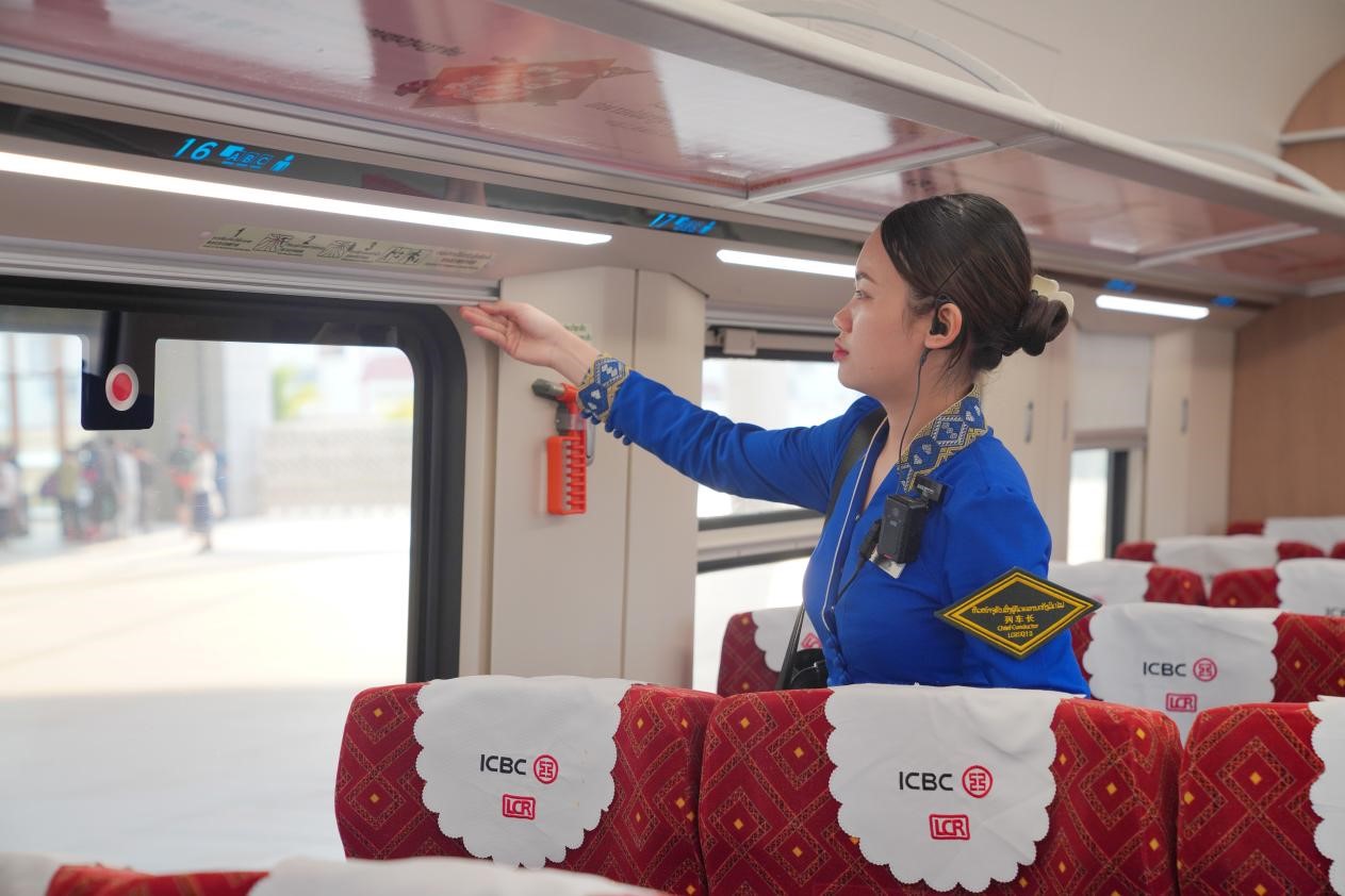 中老鐵路瀾滄號(hào)動(dòng)車組列車長(zhǎng)小麗正在進(jìn)行車廂檢查。老中鐵路有限公司供圖